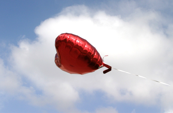 Red Mylar Heart Balloon Against Sky